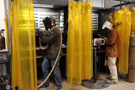 Photo of two workers welding