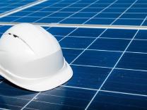 Photo of a white hard hat sitting on solar panels